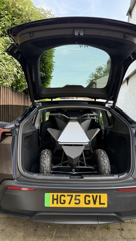Boot open in a driveway with Cybertruck model